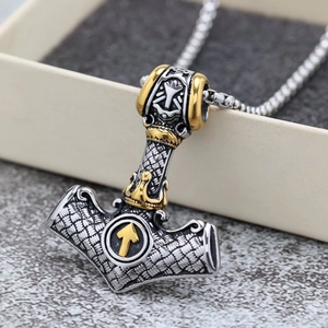 Detailed close-up of a silver Mjölnir pendant with golden Viking symbols and steel chain