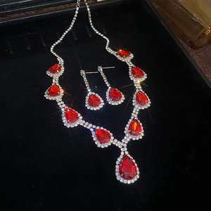 Detailed view of luxury red pear-cut crystal necklace and earrings in a velvet gift box