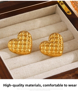 Detailed macro view of 18K gold plated heart earrings with diamond lattice pattern in a box