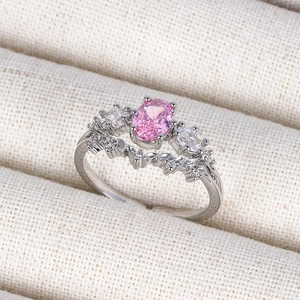 Macro detail of the 18K silver ring with a pink oval gemstone and wavy pave-set diamonds