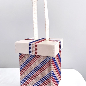 Detailed view of rhinestone clutch with red white blue diagonal stripes and dual handles