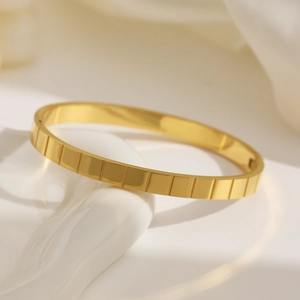 Dettaglio macro del bracciale in acciaio inossidabile dorato con strisce verticali