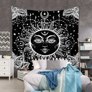 Detail of bohemian sun and moon tapestry hanging above a bed as bedroom wall decor