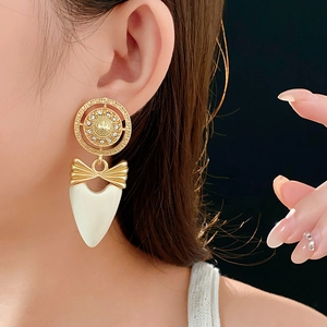 Detail of vintage bow heart earring with gold relief and crystals on model