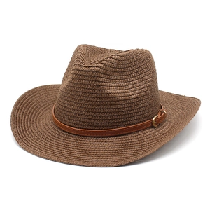 Détail de chapeau de cowboy en paille marron avec bande en similicuir et boucle dorée