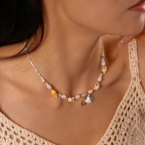 Detail of bohemian shell necklace featuring colorful glass beads and pearl accents