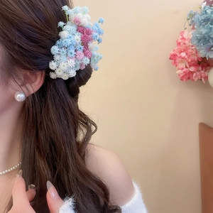Close-up of floral acrylic hair clip worn by model for elegant styling
