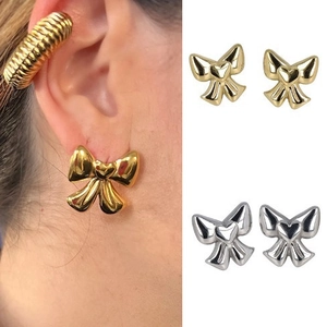 Detail view of 14K gold plated bow stud earrings with heart center and matching ear cuff