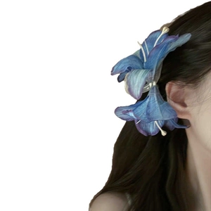 Blauwe lelie bloem haarklem voor dames met een realistisch bloemenontwerp in haar