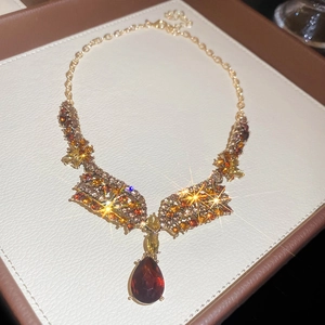 Macro shot of French vintage necklace with amber rhinestones on beige leather tray