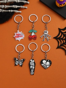 Collection of six Halloween skull keychains with spider, cherry and butterfly designs on orange