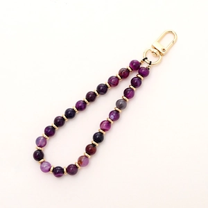Detailed view of purple marble texture beads with golden lobster clasp and metal spacers