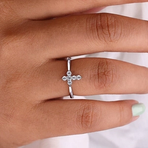 Elegant silver cross ring with micro-paved white zircons worn on finger for a chic look