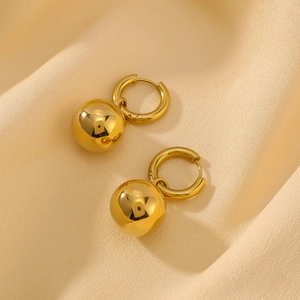 Polished hollow sphere hoop earrings in gold finish on beige silk fabric
