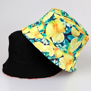 Reversible tropical fruit bucket hat featuring yellow lemon print and solid black cotton fabric