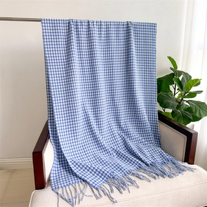 Close-up of blue and white houndstooth cashmere scarf with fringe on a chair