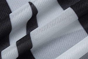 Close-up of sheer mesh fabric with black and white stripes for summer dress
