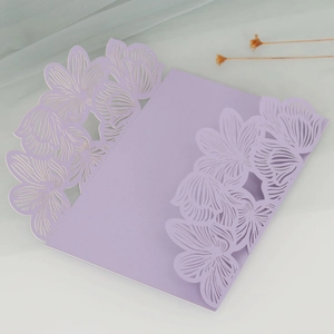 Close-up of laser-cut lavender rose wedding invitation with intricate floral hollow pattern