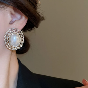 Detailed view of a French vintage gold earring featuring a large pearl and zircon halo