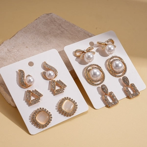 Set of twelve vintage earrings featuring faux pearls and crystals with cat eye stones in gold