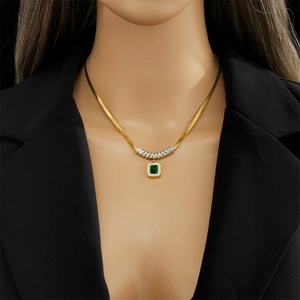 Collana a catena serpente dorata con ciondolo quadrato in gemma verde su una modella