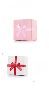 Detail of square jewelry boxes with elegant ribbon bows and textured paper finish