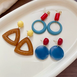 Detailed display of colorful geometric resin earrings in a ceramic tray for a trendy look