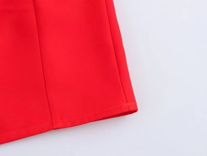 Detailed close-up of a red mini dress showing woven fabric texture and hem stitching