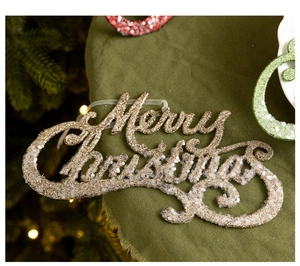 Close-up of champagne gold Merry Christmas pendant with festive glitter and white texture