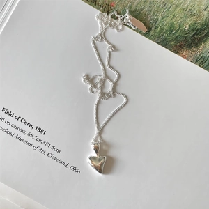 Minimalist 925 sterling silver necklace with irregular heart pendant on artistic background