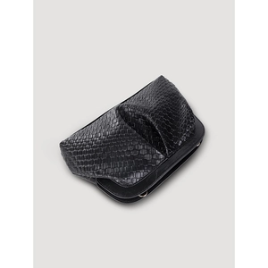 Detail view of black woven faux leather bag with magnetic closure and ruched texture