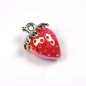 Macro detail of red strawberry pendant with golden leaves and sparkling rhinestones