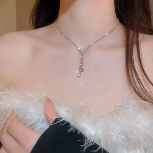 Detail of silver Y-shaped necklace with rhinestones on a female model neck