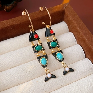 Detail of vintage fish earrings with colorful beads in a brown velvet jewelry box