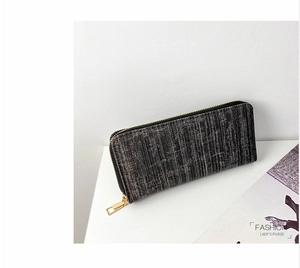 Detail of dark grey textured long wallet featuring a premium golden metal zipper closure