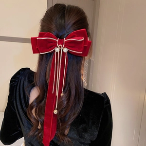 Detail of red velvet bow hair clip with pearl and rhinestone tassel on hair