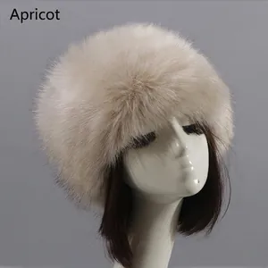 Close-up of thick apricot faux fur hat with plush texture on display stand