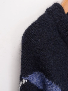 Dettaglio macro della maglia a rombi soffice in blu navy e bianco tipo mohair
