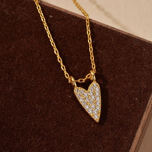 Elegant gold S925 silver heart necklace with pavé cubic zirconia on brown velvet base