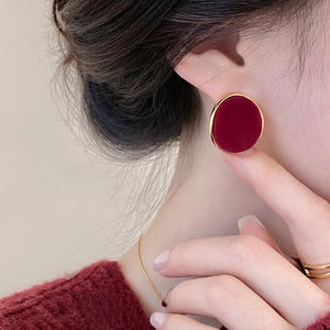 Elegant wine red velvet round stud earrings with golden metallic edge worn by model