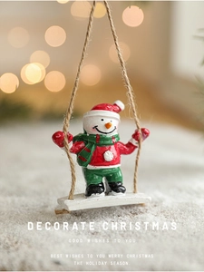 Detail of hand-painted resin snowman swing ornament with festive red and green winter attire
