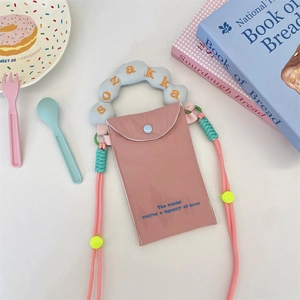Detail showing pink canvas phone bag with cloud handle and adjustable mint green strap