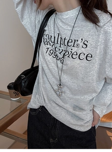 Close-up of Y2K silver balloon dog pendant necklace worn with grey lettered streetwear t-shirt