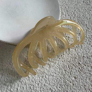 Detailed view of the 13cm translucent amber octopus hair claw clip for thick hair