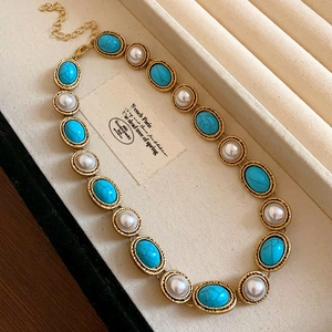 Detail of vintage gold necklace with resin turquoise and pearls in a jewelry box