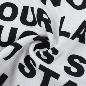 Close-up of white ribbed knit fabric featuring bold black letter printing and soft texture