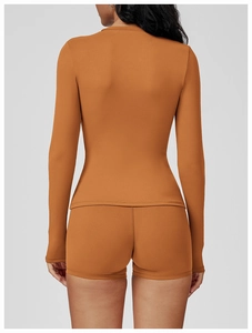 Rear view of caramel athletic two-piece set featuring long-sleeve top and high-waist shorts