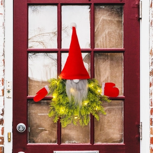 Lighted Christmas gnome wreath with red hat and LED lights on a rustic wooden door