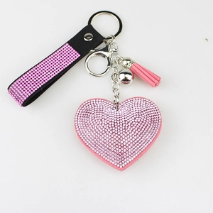 Detailed view of pink heart keychain with glittering rhinestones and tassel accent