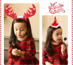 Close-up of reindeer antler and Santa hat headbands worn by a girl for Christmas party